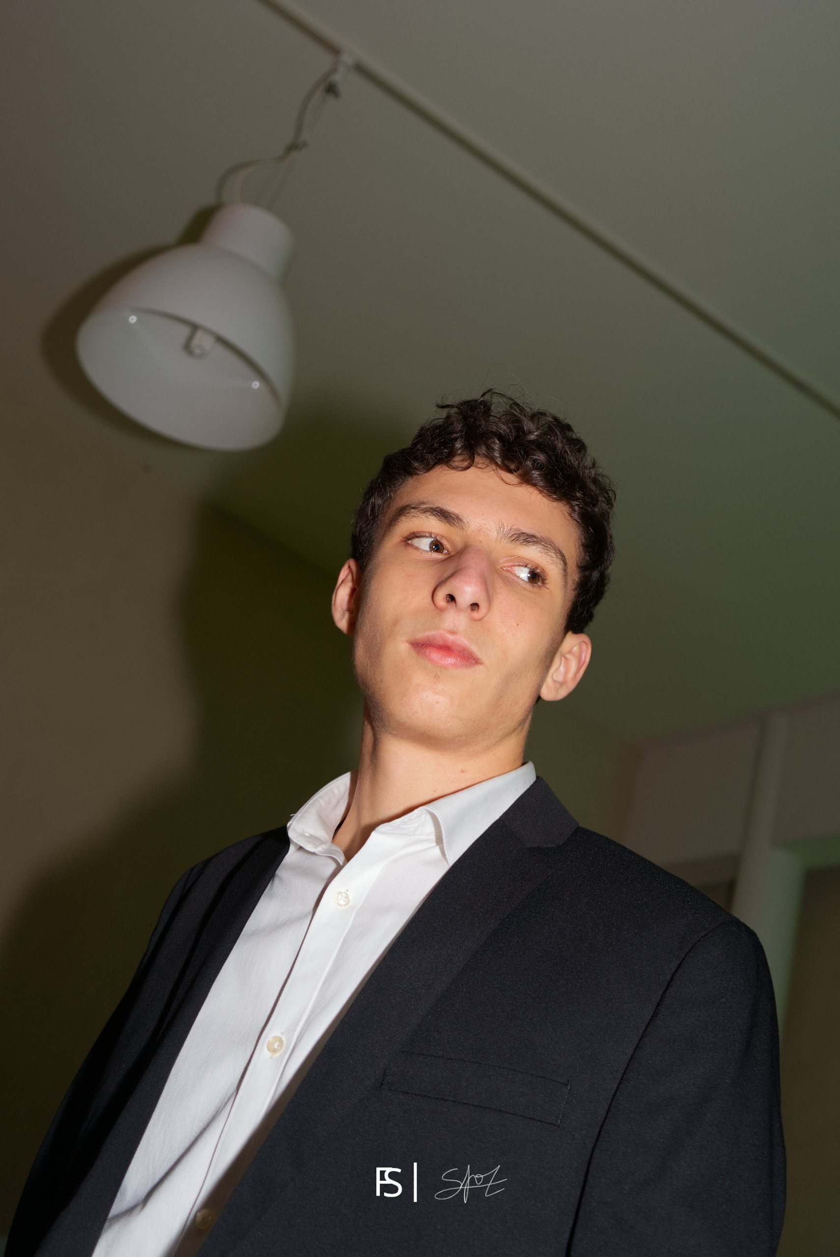 Ritratto dal basso con il flash di un ragazzo in giacca e camicia bianca